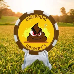 Brown and white golf ball marker poker chip featuring an animated steaming pile of poop, dropping grumpys, on a bright yellow background.